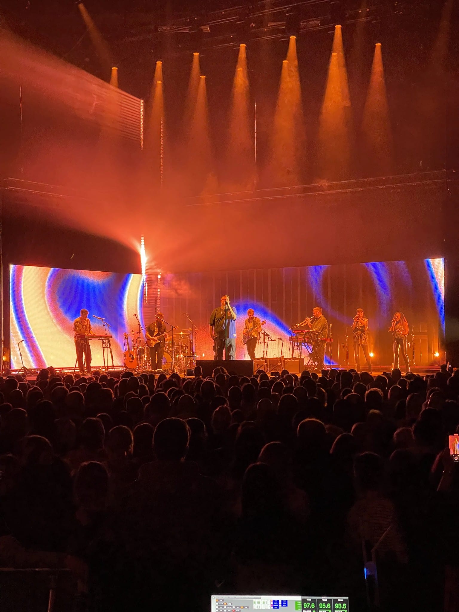 Show look: orange and blue LED wall, band and crowd, media-server desk in the foreground, Rag'n'Bone Man 2024 UK and EU tour.